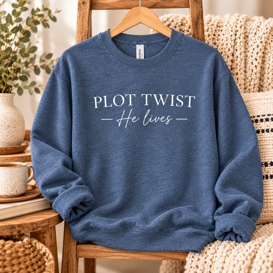 Heathered indigo-blue crewneck with white Plot Twist — He Lives lettering.